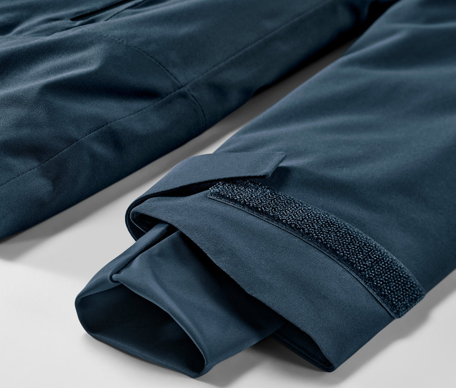 Detail námorníckej modrej lyžiarskej bundy.