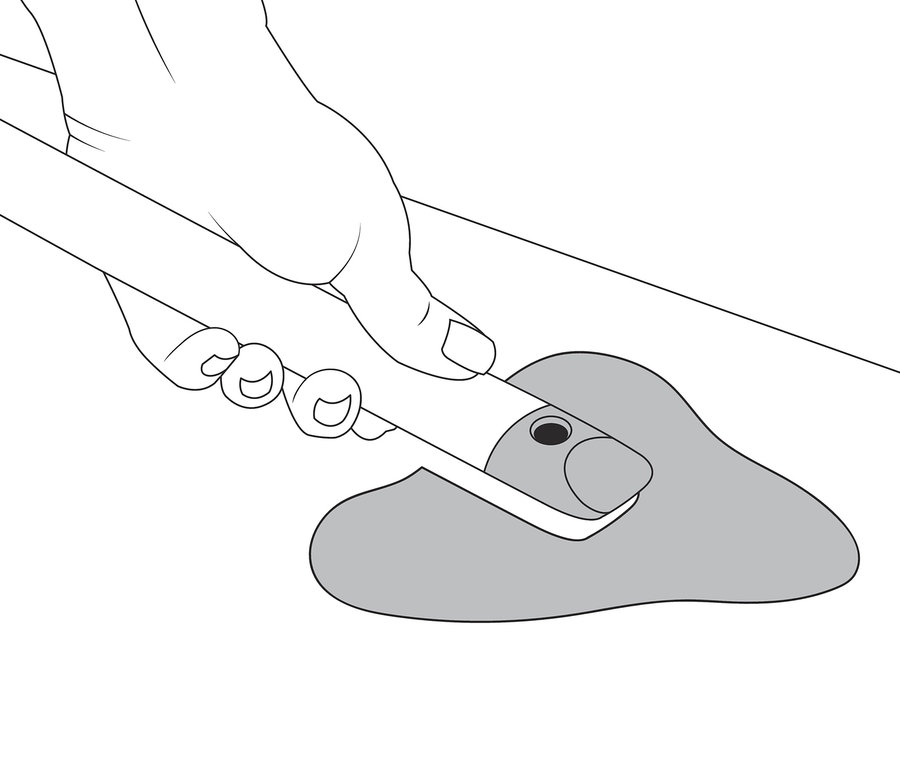 Ruka drží pomôcku na škárovanie 4 v 1 a čistí sivú špinu.