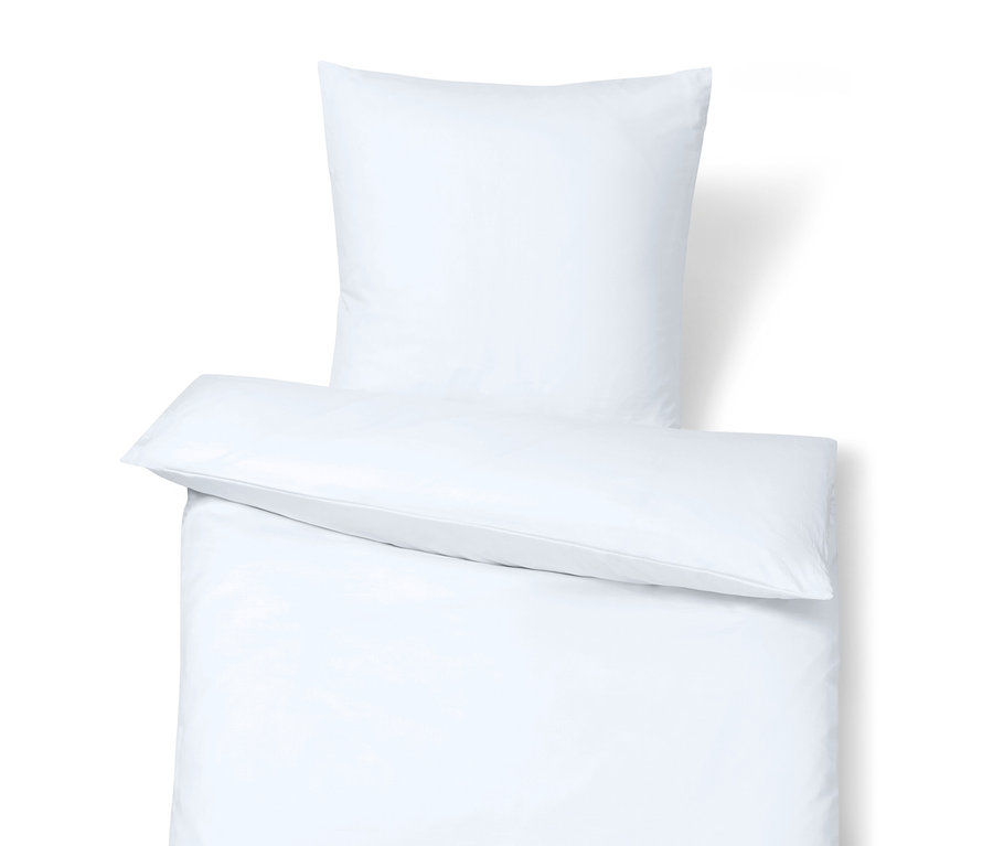 Detail bielej posteľnej bielizne s vankúšom navrchu.