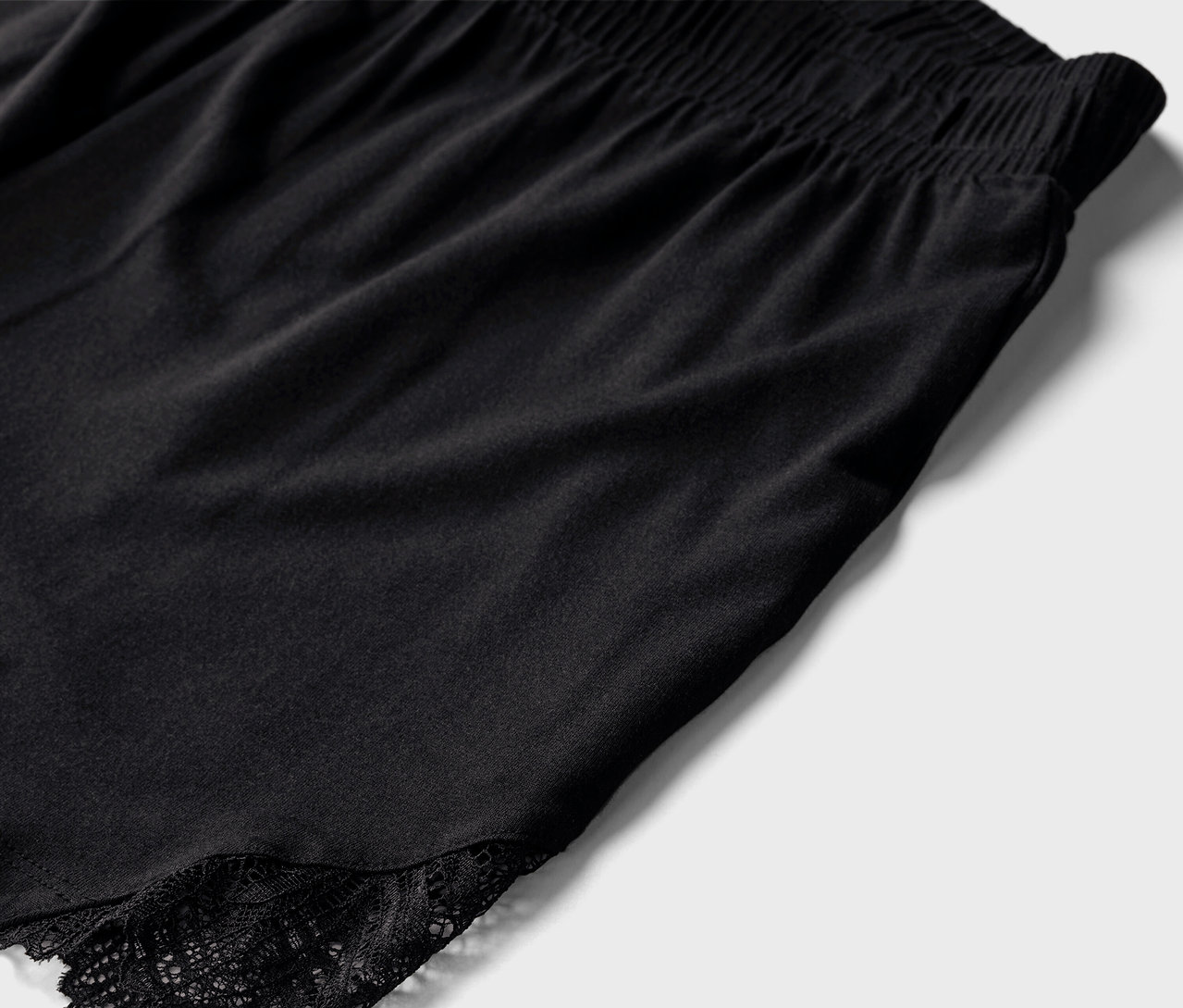 Detail čierneho krátkeho pyžama s čipkou.