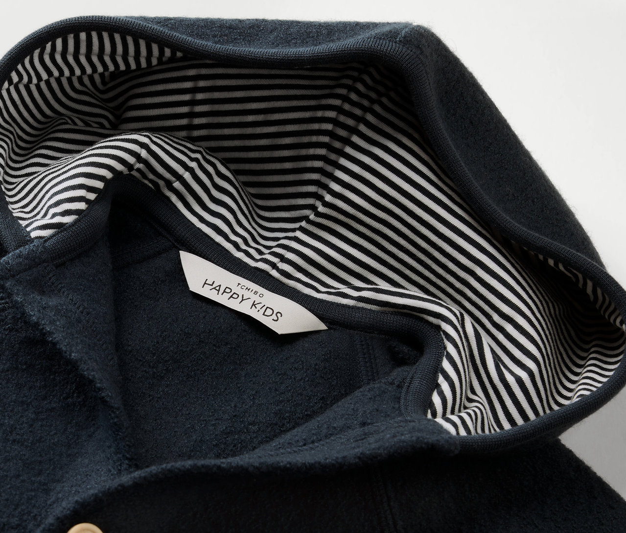 Detailný pohľad na modrý detský overal Baby-Walkoverall mit Merinowolle s kapucňou a pruhovanou podšívkou.