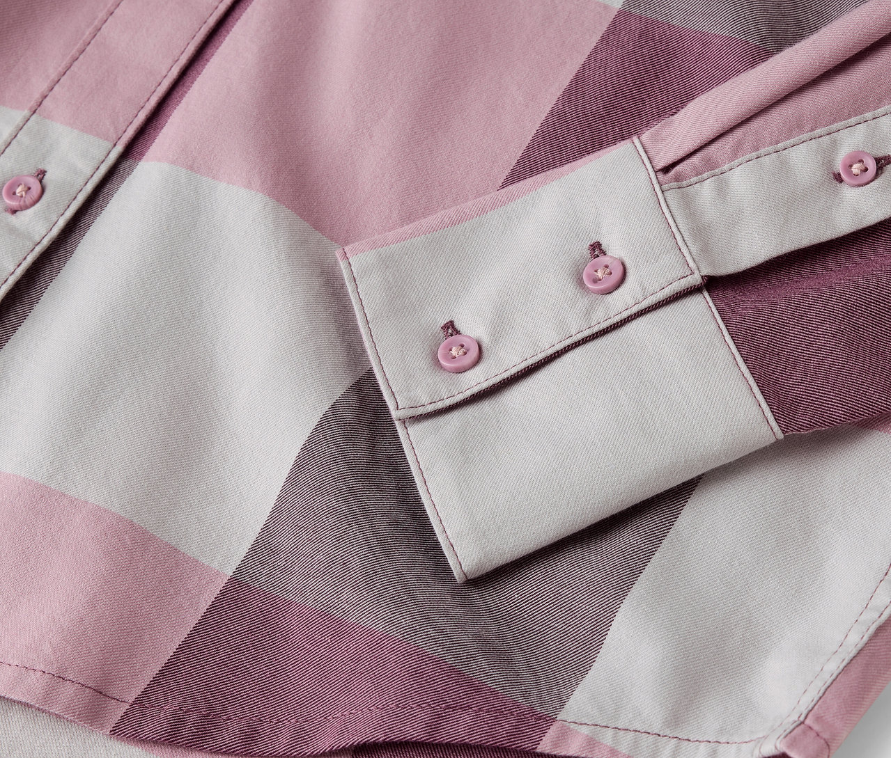 Detail ružovo-bielej kockovanej košele s gombíkmi.