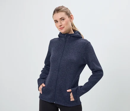 Žena má na sebe tmavomodrú mikinu s kapucňou na zips a čierne nohavice.