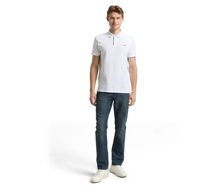 Muž v bielom polo tričku a Tom Tailor TT MARVIN STRAIGHT Jeans mit Stretch, Mid Stone Blue Grey Denim a bielych topánkach.