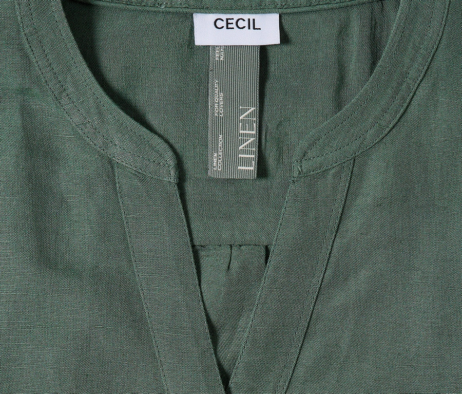 Detailný záber na zelenú ľanovú košeľu Cecil s výstrihom do V a štítkom.