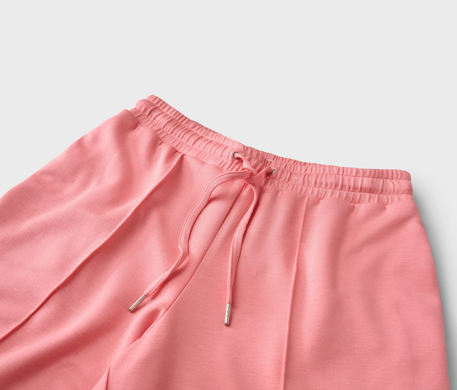 Detailný záber na koralové nohavice so šnúrkou.