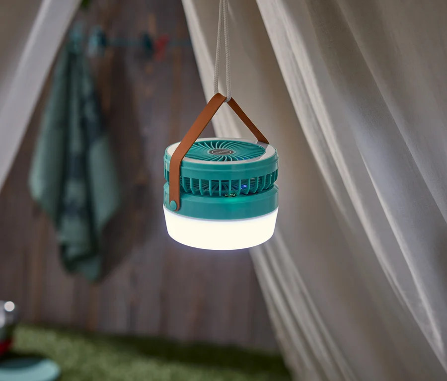 Tyrkysová lampa s hnedým popruhom a bielym lanom visí v stane.