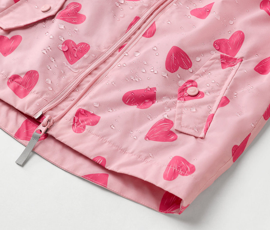 Detailný záber na ružovú vetrovku s potlačou srdca a kvapkami vody.