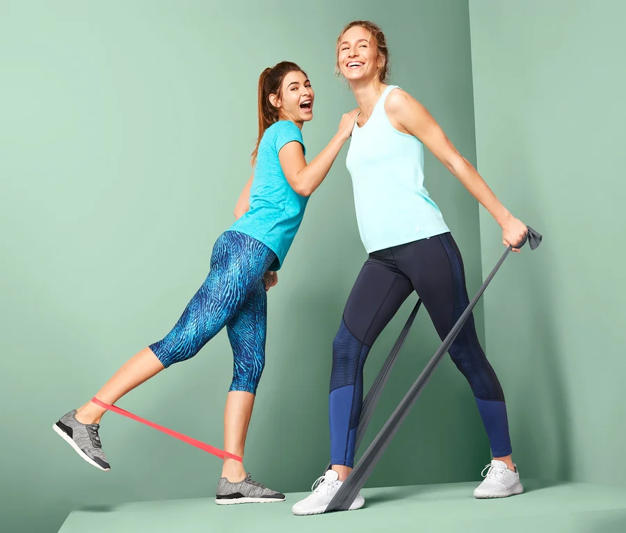 Dve ženy cvičia s 2 fitness gumami a 2 posilňovacími gumami.