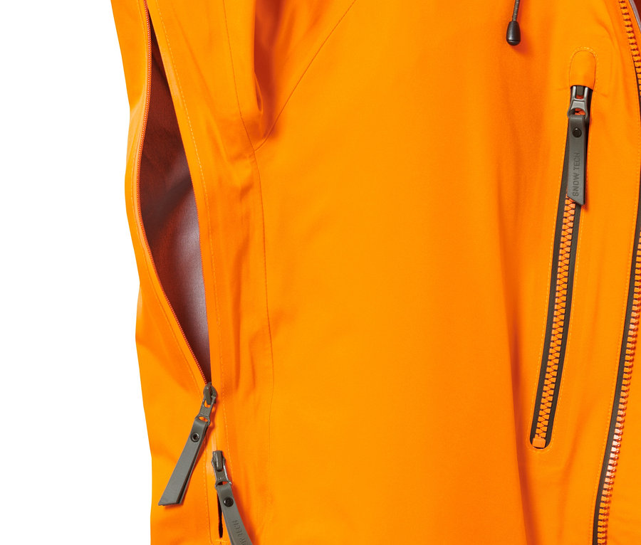 Detail oranžovej hardshellovej lyžiarskej bundy so zipsami.
