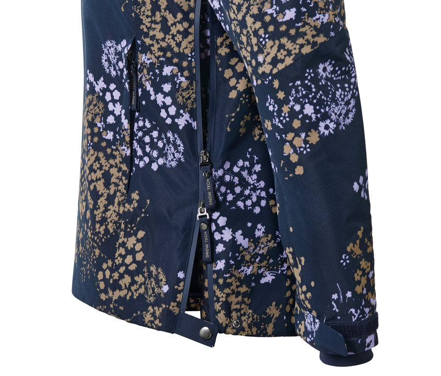 Detail lyžiarskej bundy s polovičným zipsom s kvetinovou potlačou.