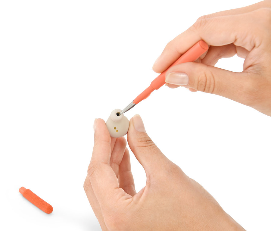 Ruky čistia slúchadlo pomocou súpravy na čistenie na písací stôl 4 v 1.