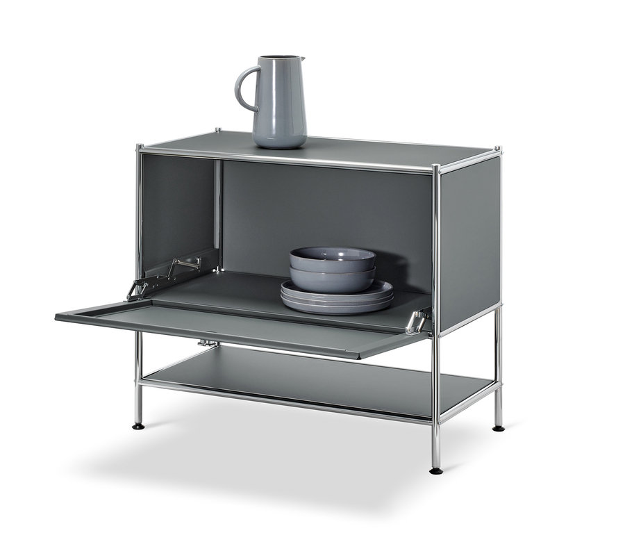Sivá odkladacia skrinka »CN3« s otvorenými výklopnými dvierkami. Na hornej časti skrinky je sivá váza, vo vnútri sú sivé misky a taniere.