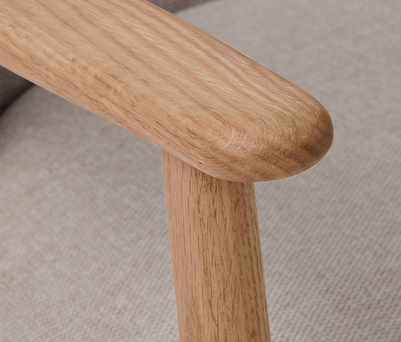 Detailný záber na drevenú lakťovú opierku kresla.