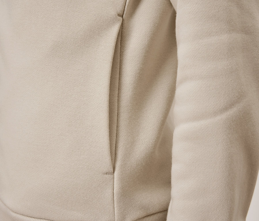 Detail béžovej mikiny s vreckom.