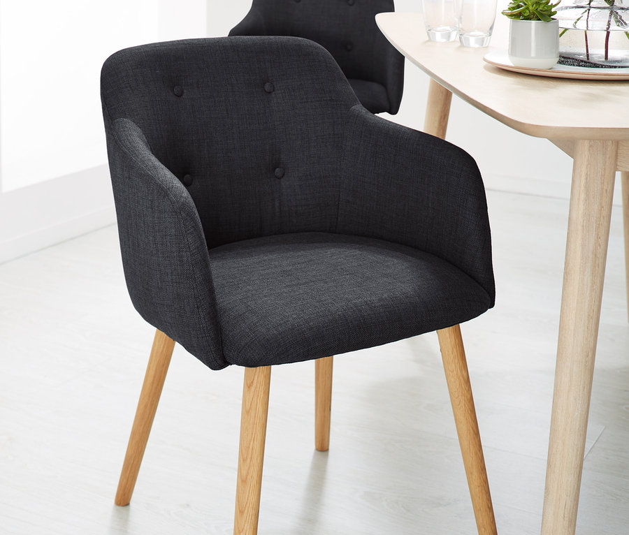 Dve antracitové čalúnené stoličky pri stole.