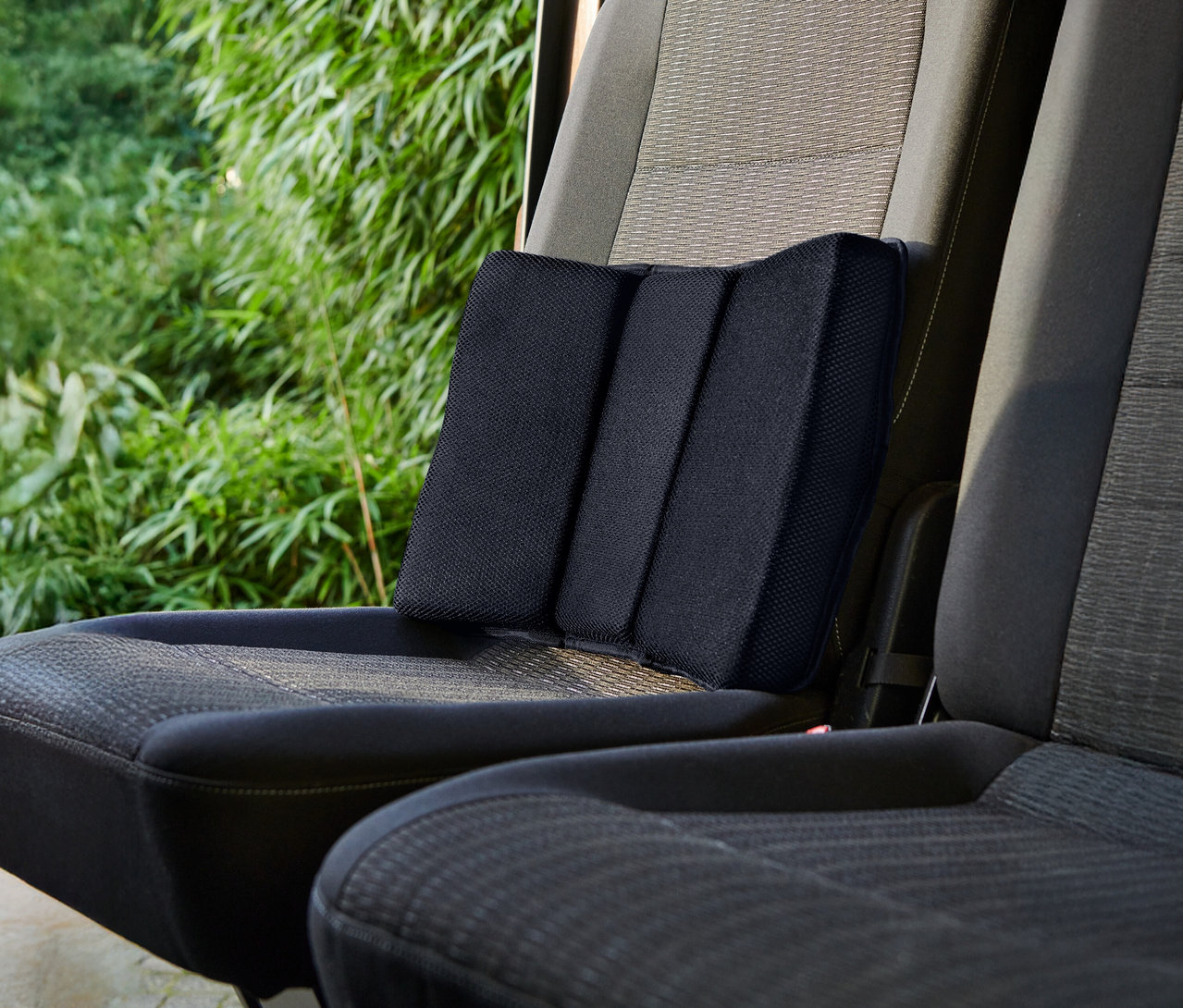 Čierny bedrový vankúš umiestnený na autosedačke.