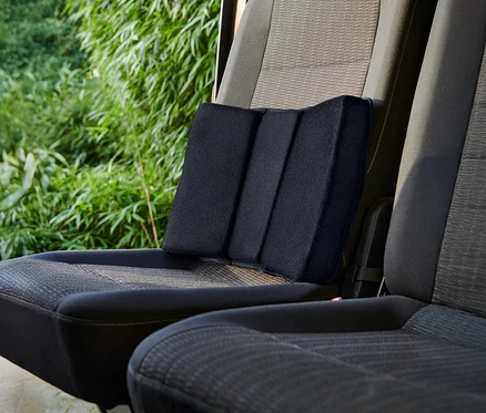 Čierny bedrový vankúš umiestnený na autosedačke.