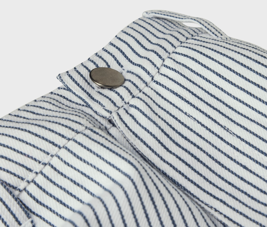 Detail detských tkaných nohavíc s modrými prúžkami a gombíkom.