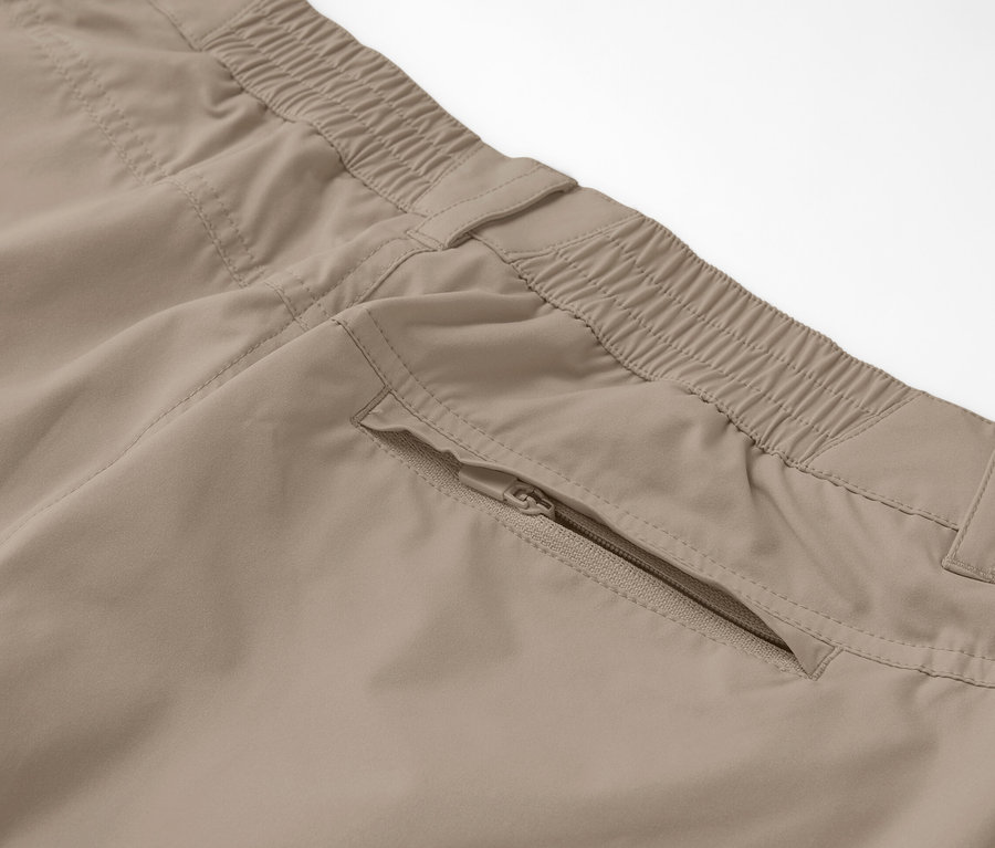 Detail béžových funkčných nohavíc 2 v 1 so zipsovým vreckom.