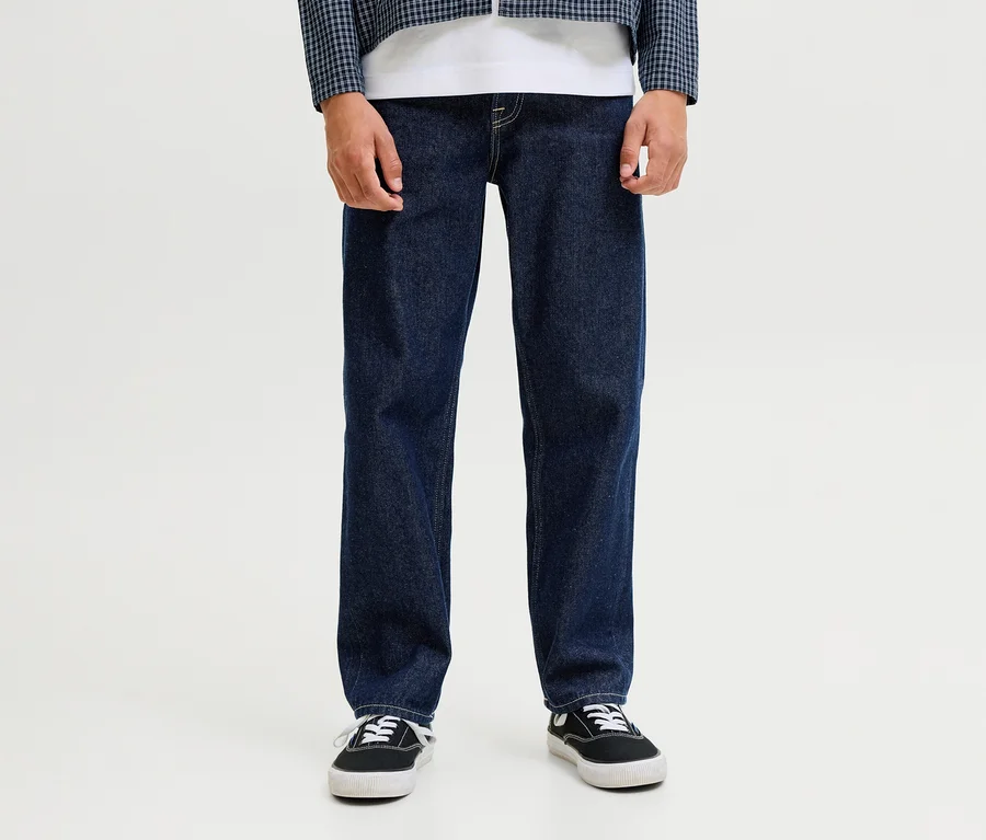 Osoba má na sebe tmavomodré džínsy Jack&Jones JJOriginal Chris, biele tričko, modro-bielu kockovanú bundu a čierne tenisky.
