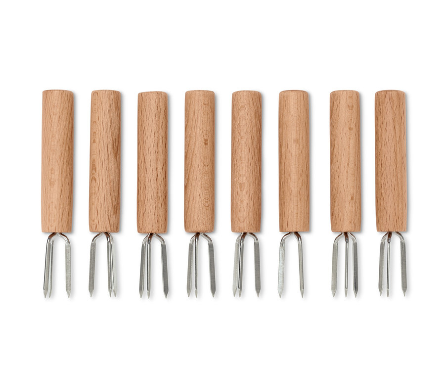 Osem držiakov na kukuricu s drevenou rukoväťou a striebornými hrotmi usporiadaných v rade.