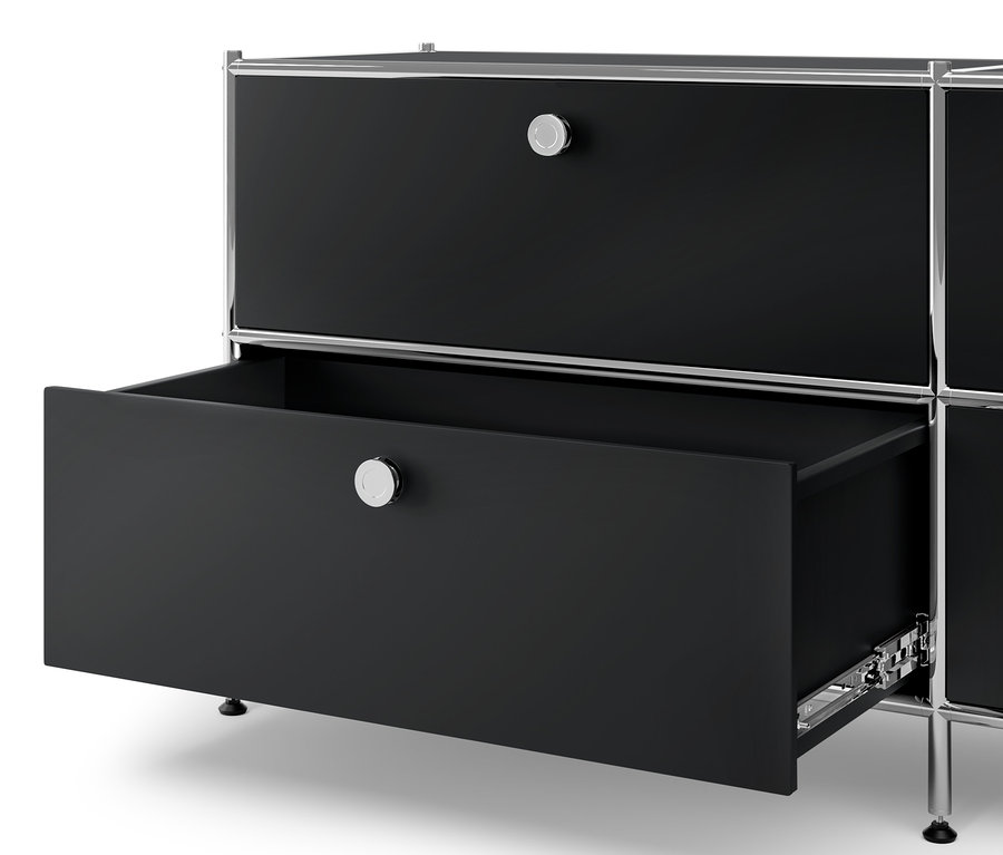 Detail čiernej kovovej komody »CN3« so 6 zásuvkami a kovovej nízkej skrinky »CN3« so 4 zásuvkami, pričom jedna zásuvka je otvorená.