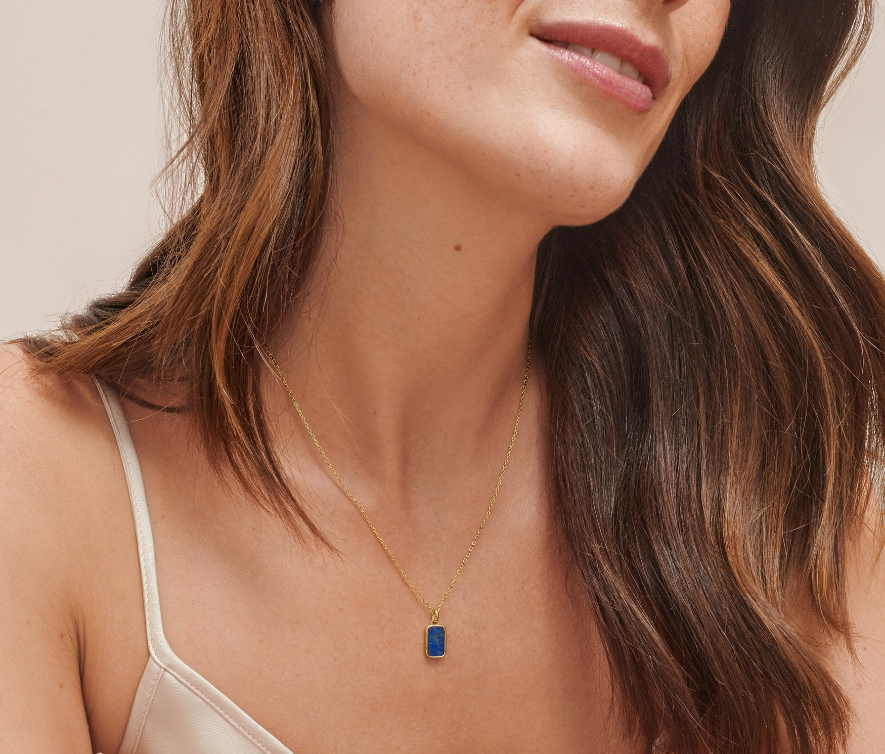 Žena má na sebe kreoly zo striebra 925, dvojfarebné a retiazku zo striebra 925, pozlátenú, s polodrahokamom lapis lazuli.