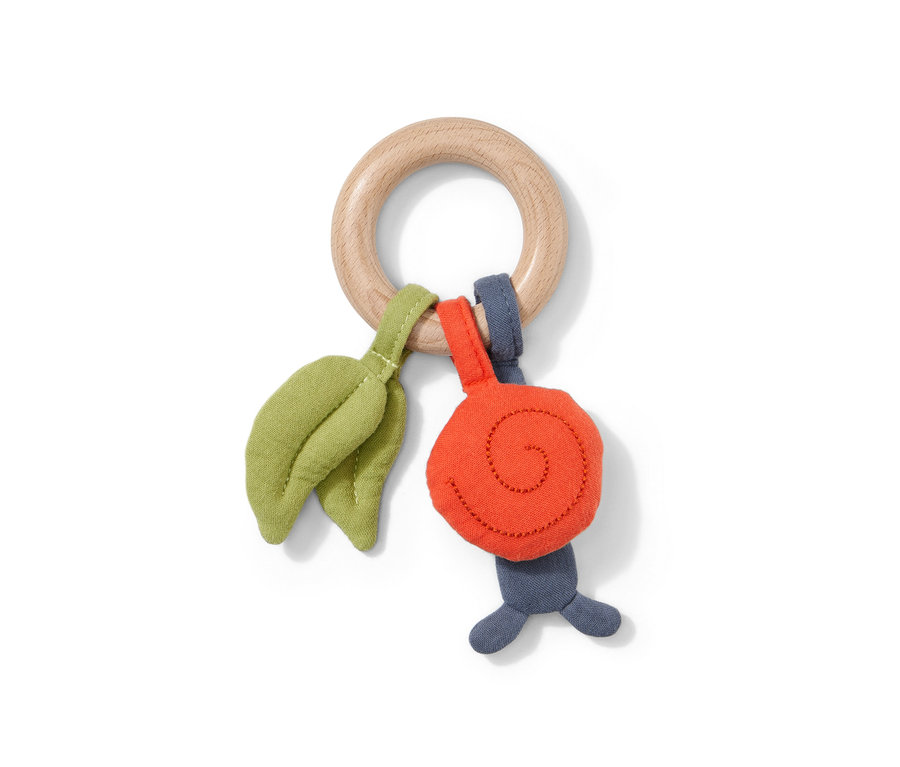 Hmatová hračka s dreveným kruhom, látkovými listami a slimákom.