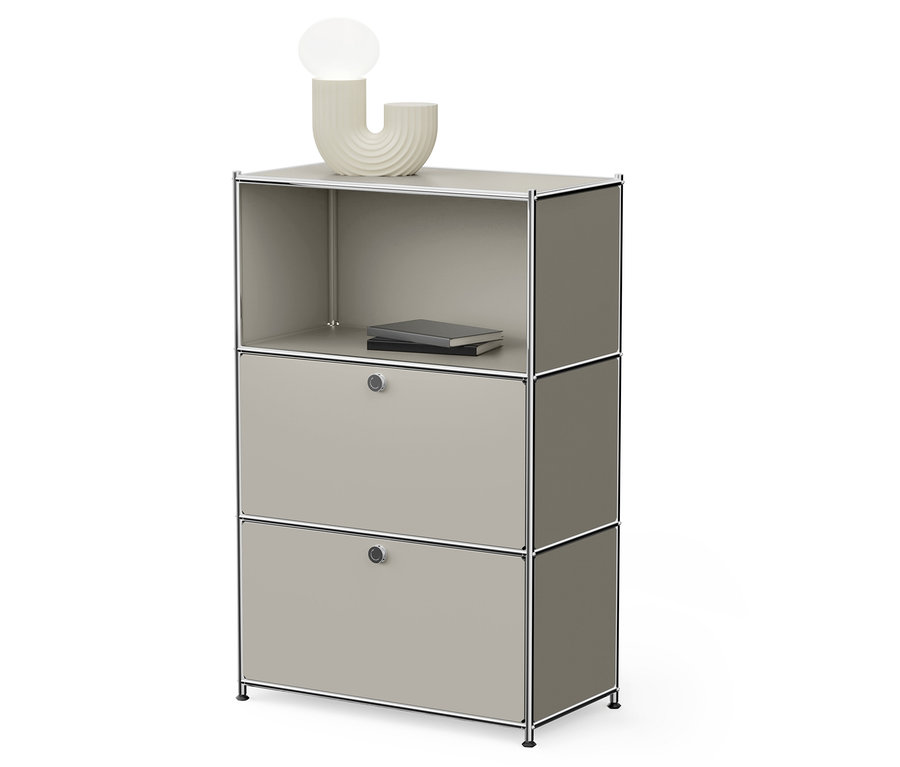 Sivá modulárna skrinka s dvoma zásuvkami a otvorenou policou hore, na ktorej leží kniha a stojí lampa.