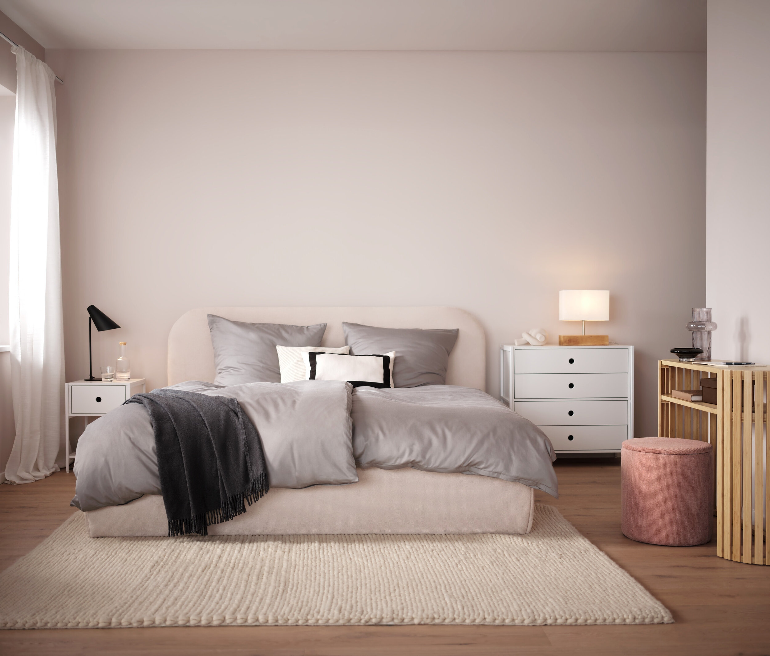 Spálňa s béžovou posteľou, sivou posteľnou bielizňou a béžovým kobercom. V pozadí biely nočný stolík a komoda.