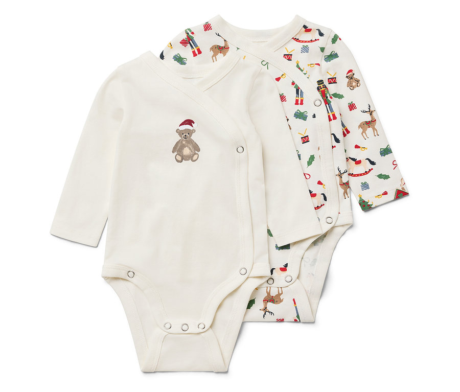 Dve biele body s dlhým rukávom. Jedno má hnedého medvedíka s červenou čiapkou a druhé vianočný motív.