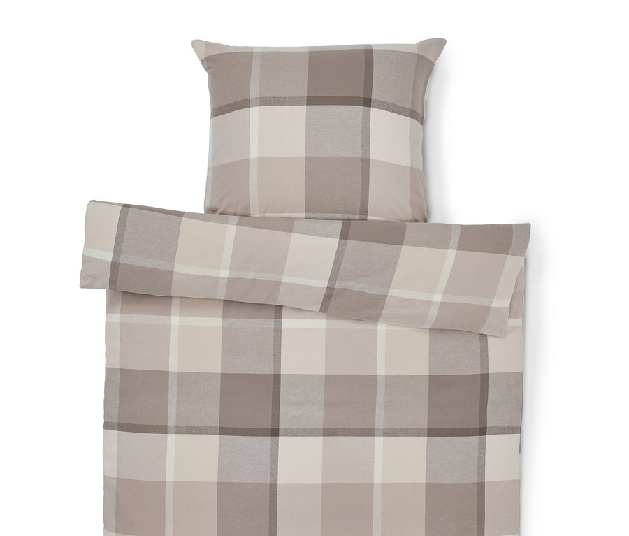 Obliečky a vankúš s károvaným vzorom v béžových odtieňoch.