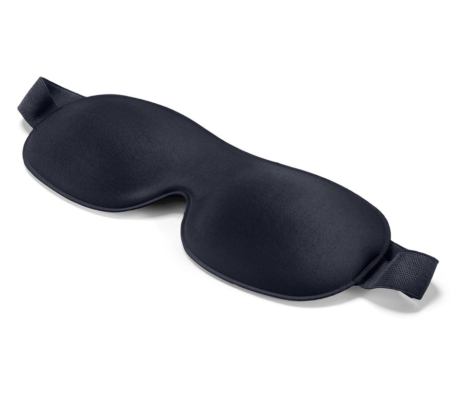 Na bielom pozadí leží tmavomodrá maska na spanie.