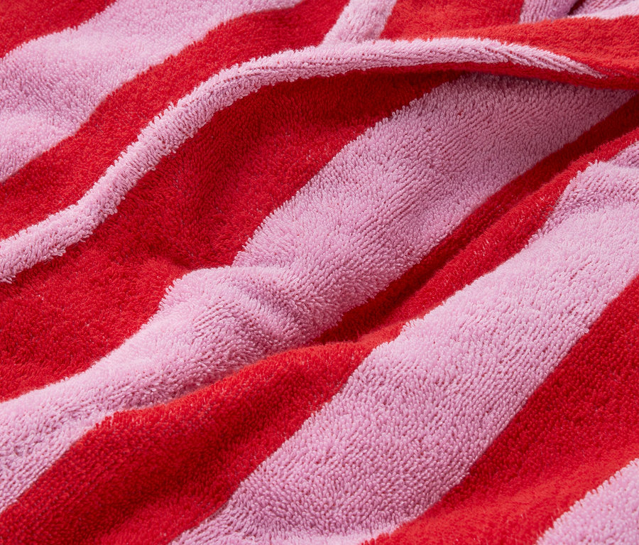 Detailný záber na červeno-ružovú pruhovanú froté látku.