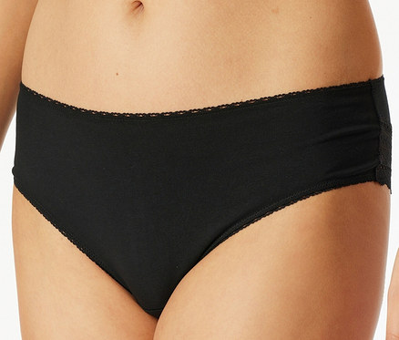 Detail dámskych čiernych nohavičiek s čipkou.