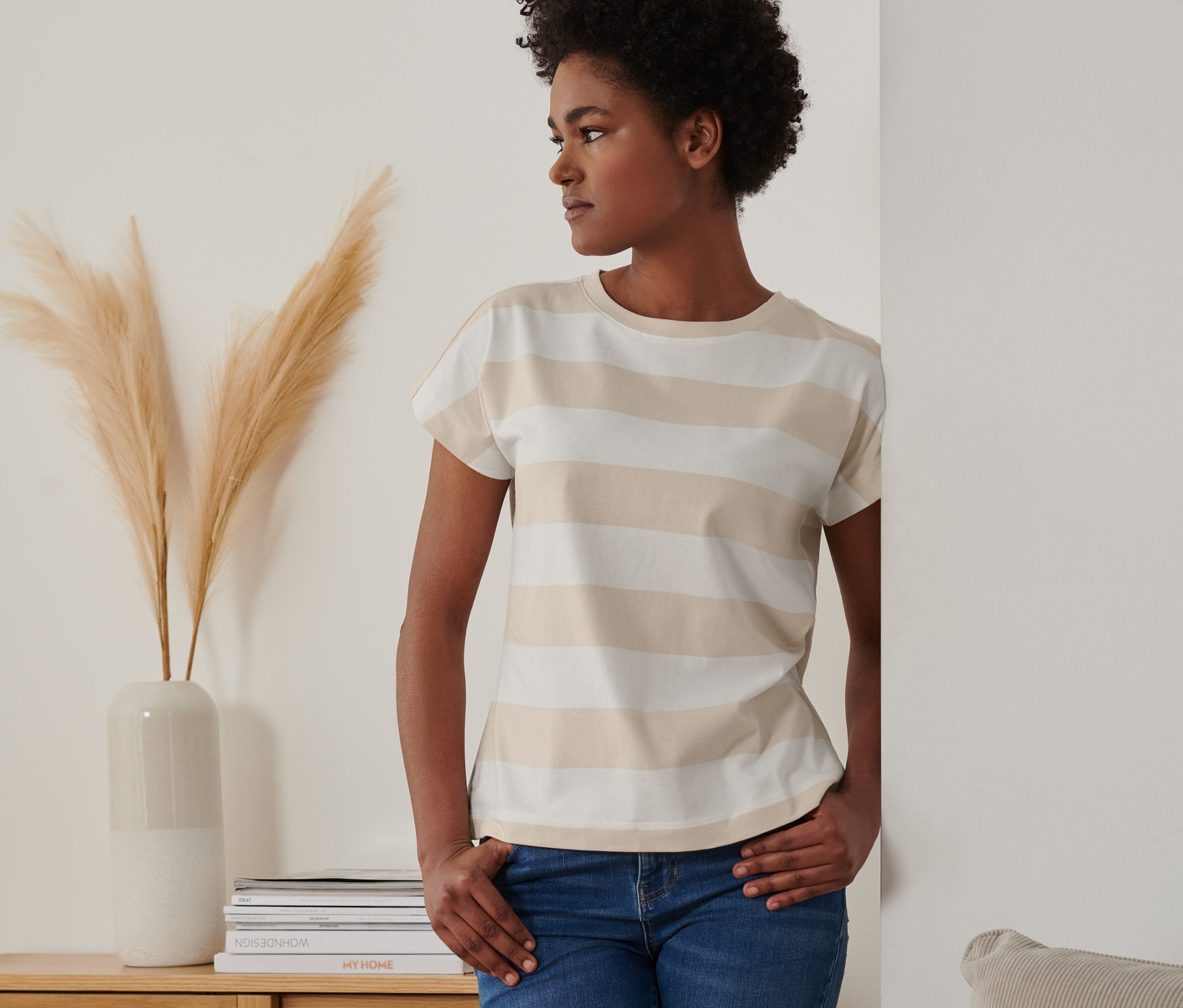 Žena pózuje v pásikavom tričku.