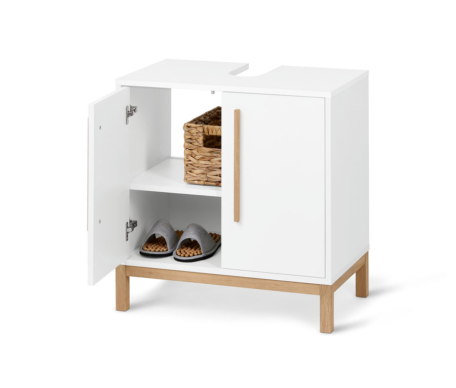 Otvorená biela kúpeľňová skrinka pod umývadlo Eklund s košíkom a papučami vnútri.