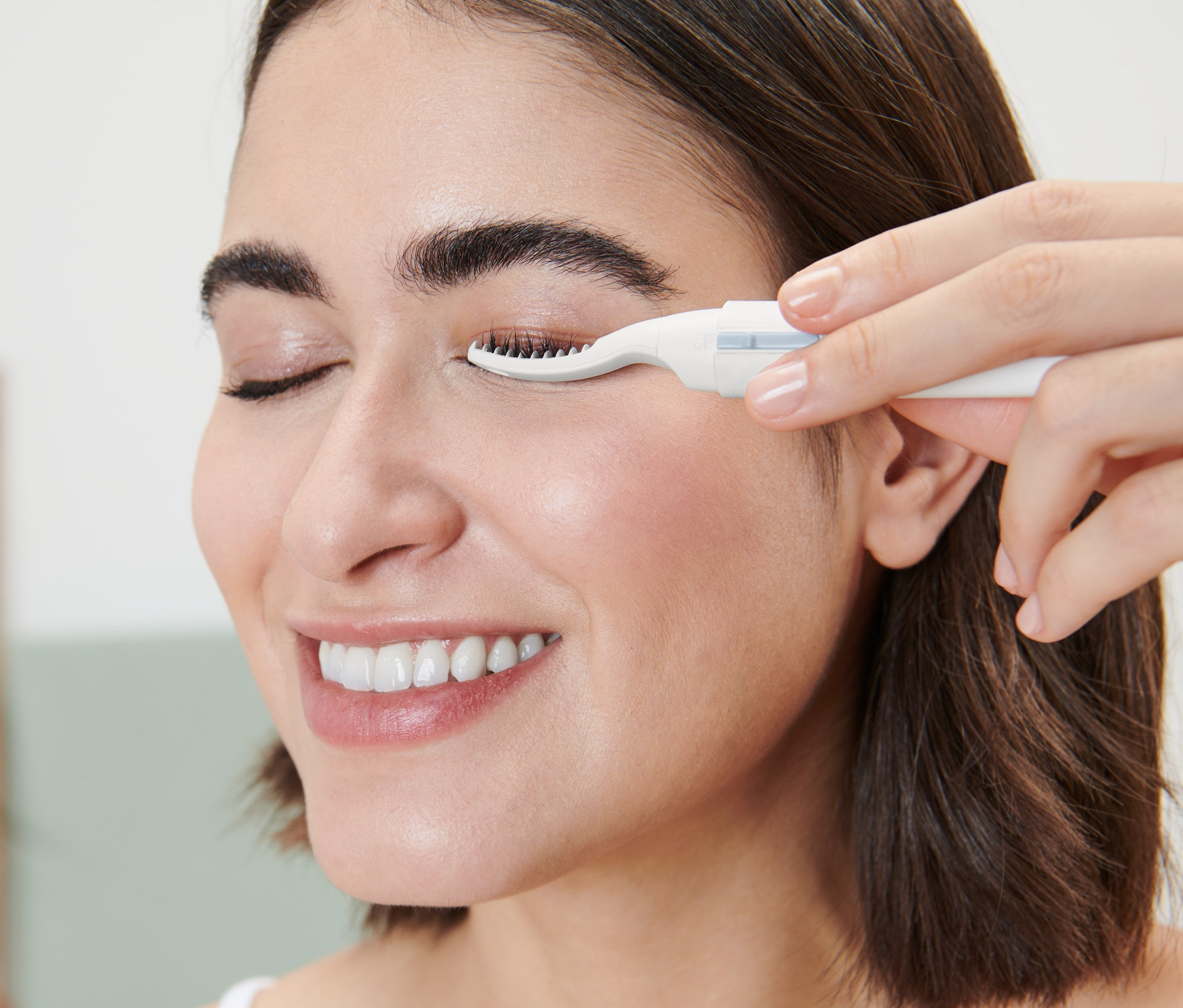 Žena používa nahrievateľnú kulmu na mihalnice.