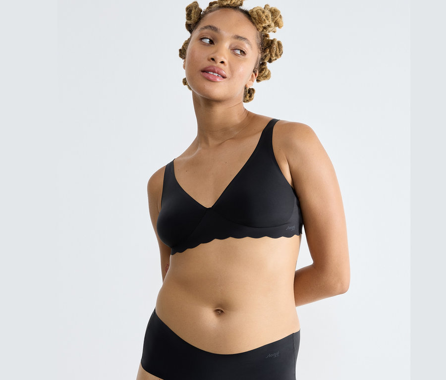 Žena má na sebe čiernu podprsenku sloggi ZERO Microfibre 2.0 Soft bra a čierne nohavičky.