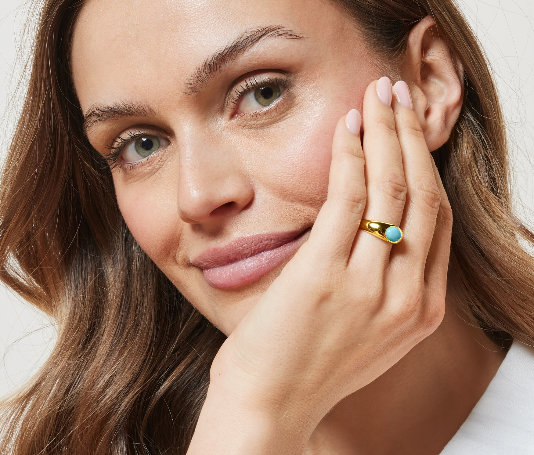 Žena so zlatým prsteňom s tyrkysovým kameňom.