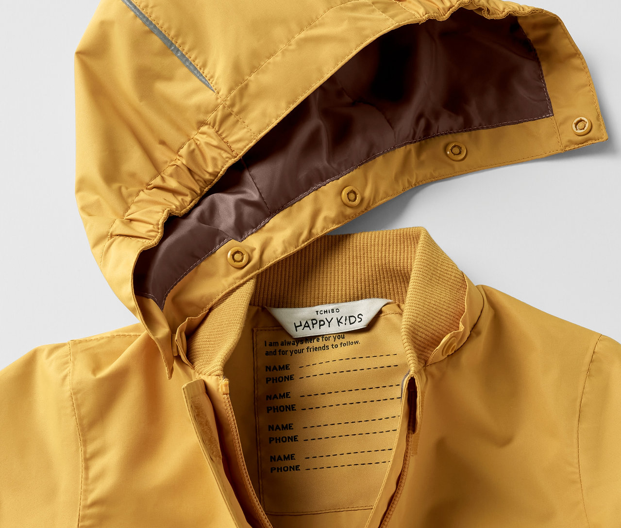 Detail žltého detského kombinéza do dažďa s kapucňou.