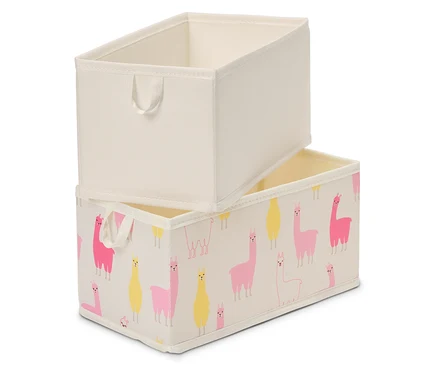 Dve obdĺžnikové úložné boxy sú naskladané na seba. Horný box je jednofarebný béžový, spodný box je potlačený ružovými a žltými lamami na béžovom pozadí.