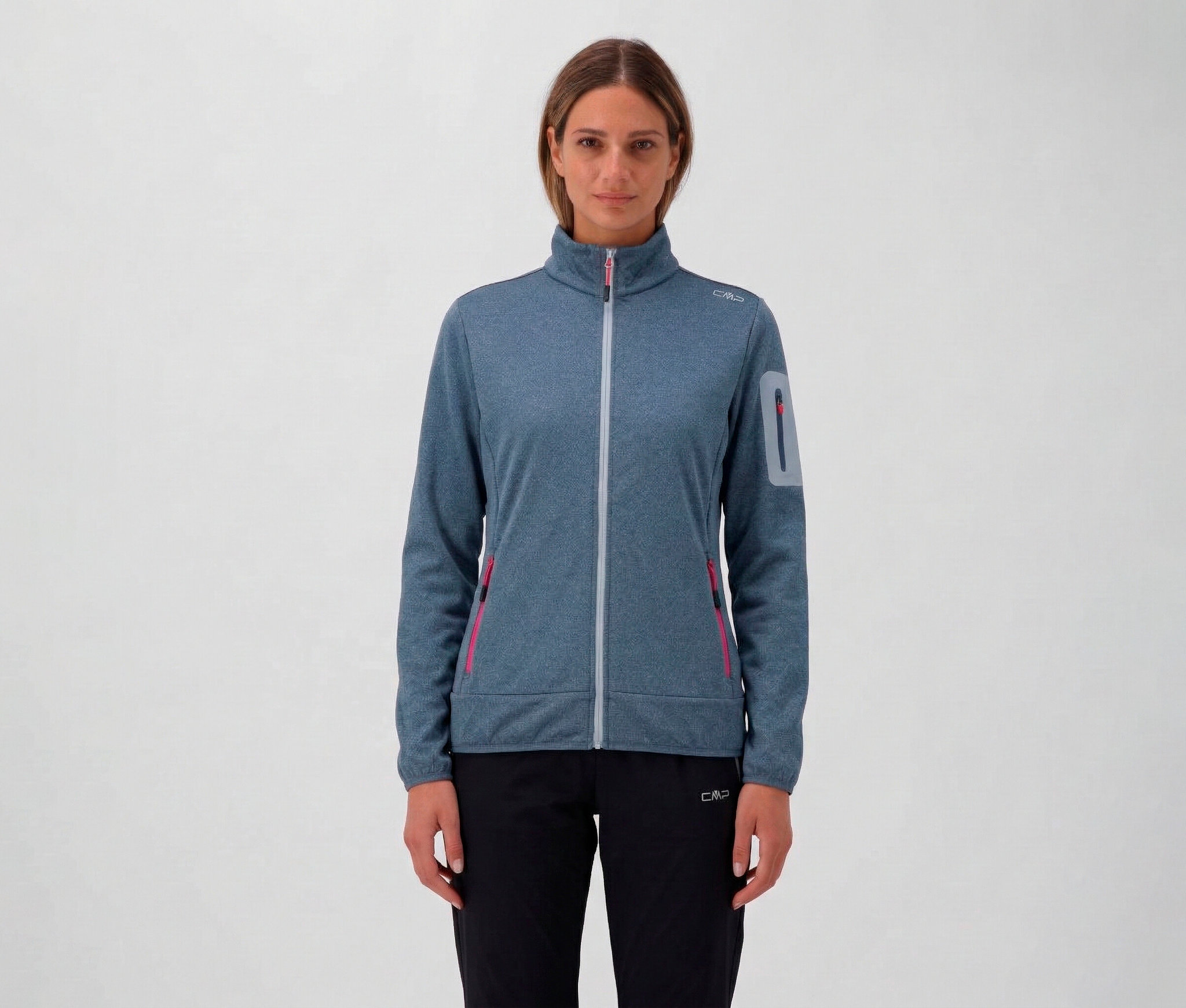 Žena v čiernych nohaviciach a modrej dámskej bunde CMP so zipsom a vreckami.