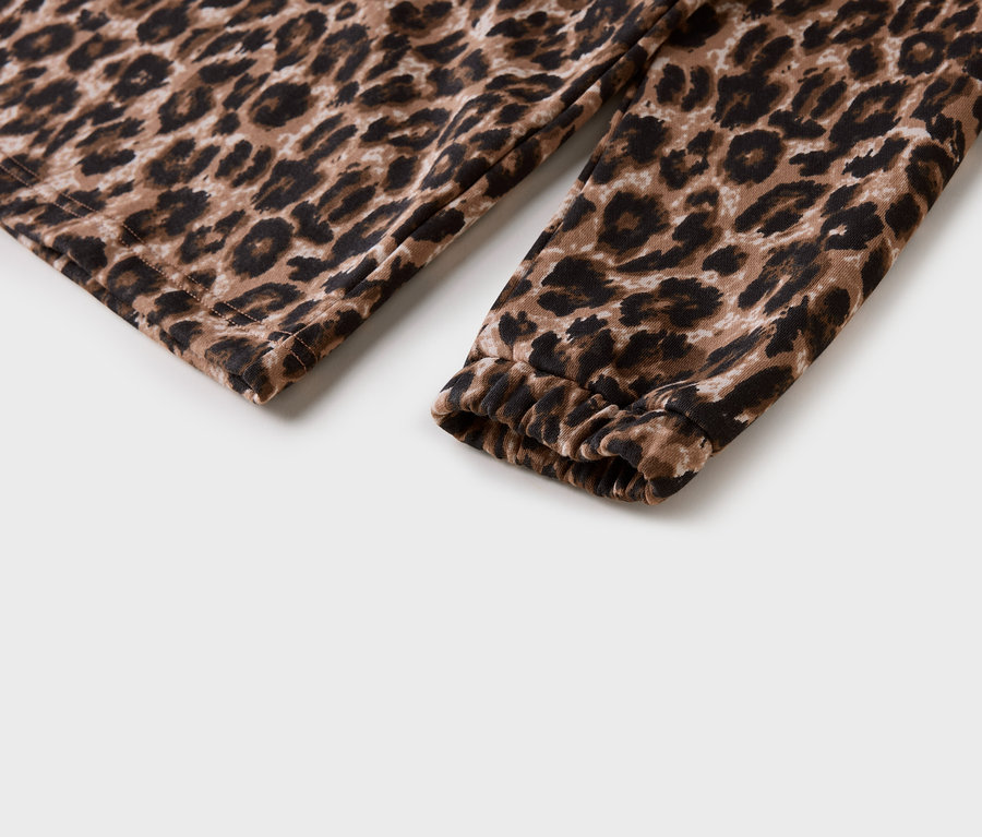 Detail rukáva s leopardím vzorom a nariaseným lemom na bielom pozadí.