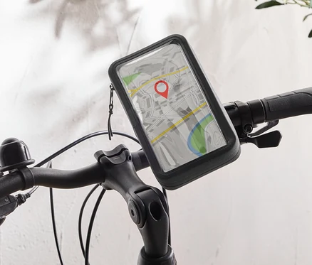 Čierny bicykel s držiakom na mobilný telefón na riadidlách, ktorý zobrazuje mapovú aplikáciu s červeným špendlíkom.