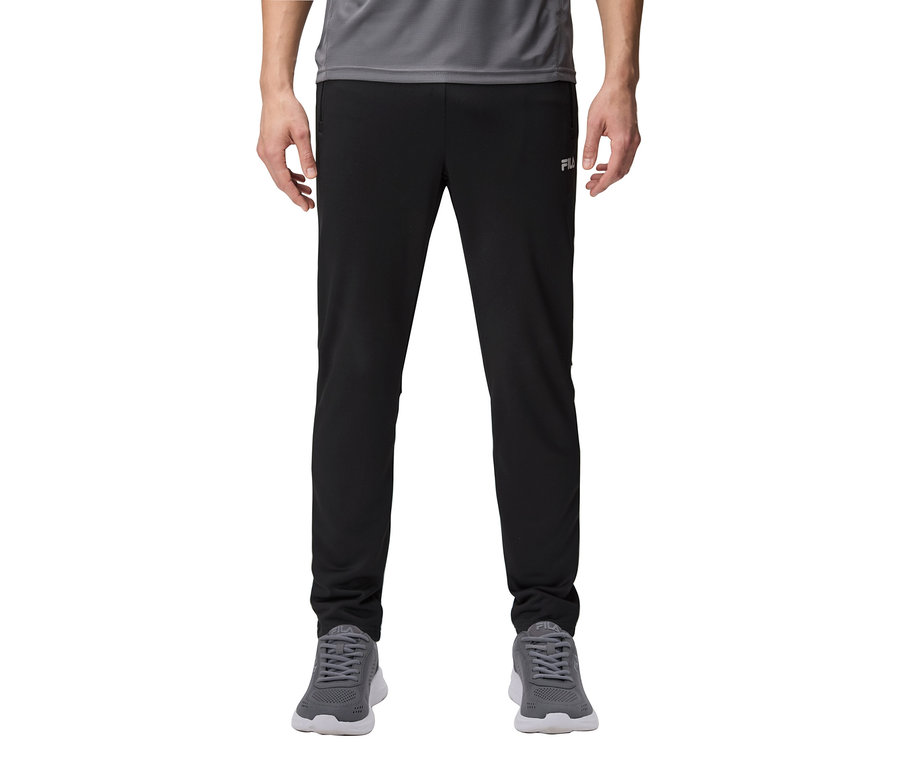 Muž má na sebe čierne tepláky a sivé tenisky.