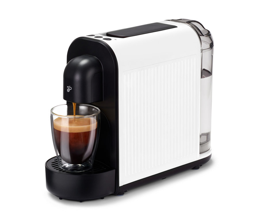 Kávovar Cafissimo now white plní šálku kávou. Kávovar je biely s čiernymi akcentmi a priehľadnou nádržkou na vodu.