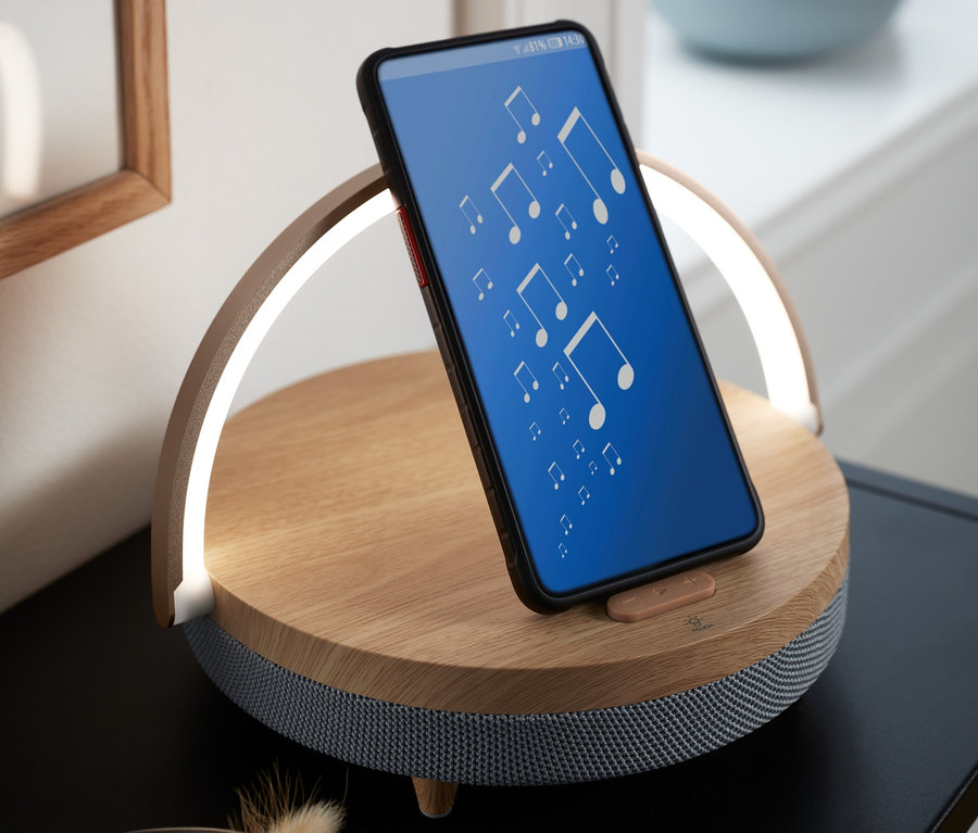 Mobilný telefón sa opiera o reproduktor s bluetooth, bezdrôtovú nabíjačkou a nočným svetlom s LED.