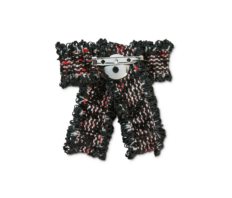 Detail brošne v tvare mašle z tvídu.